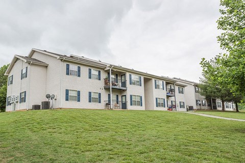 a large apartment building on top of a green lawn