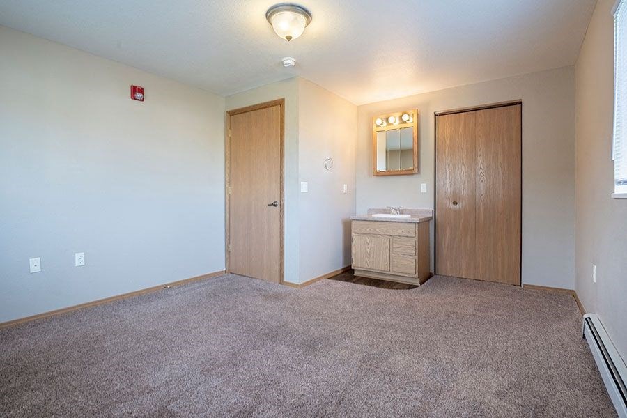 an empty room with a bathroom and a sink
