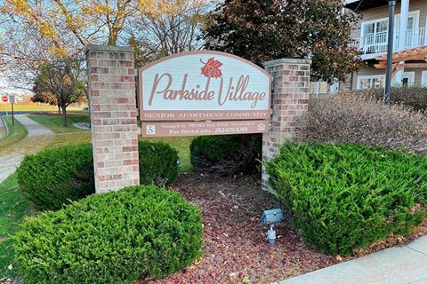 a village sign in front of a building