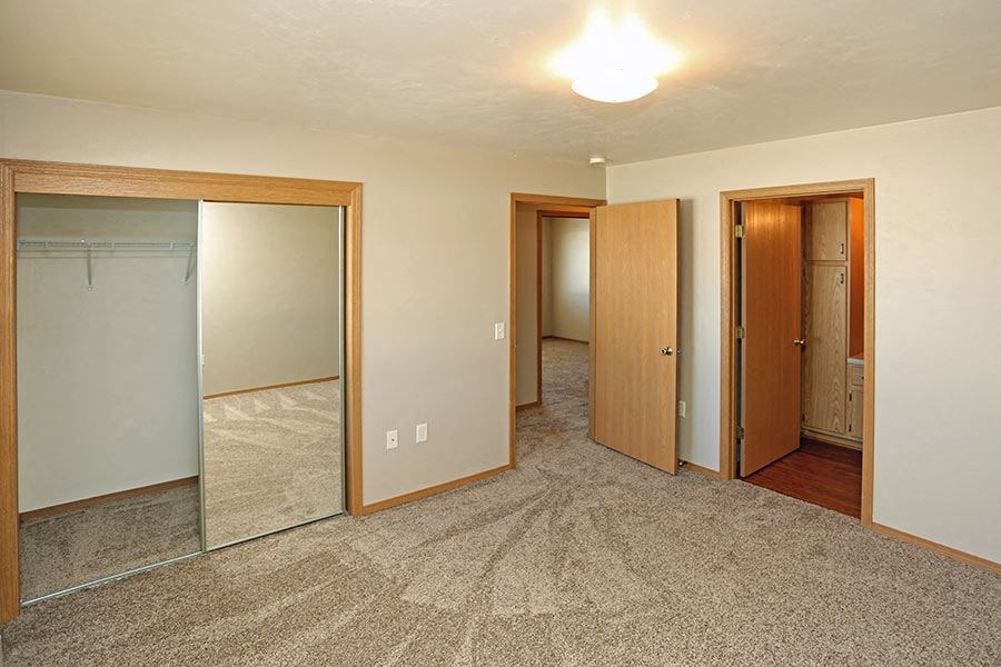 a empty room with three mirrors and a closet