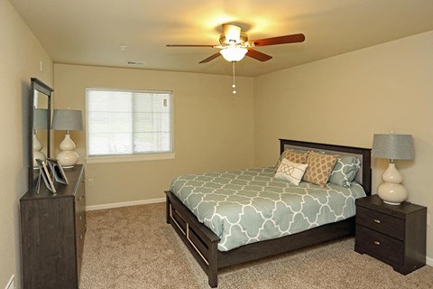 a bedroom with a bed and a ceiling fan