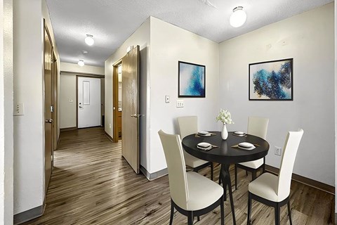 A dining room with a table set for four.