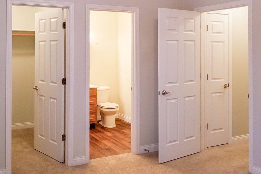 A white door is open to a bathroom with a toilet.