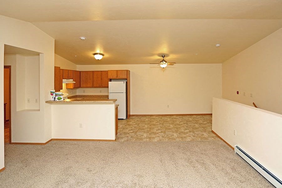 A kitchen with a refrigerator, sink, and countertop.