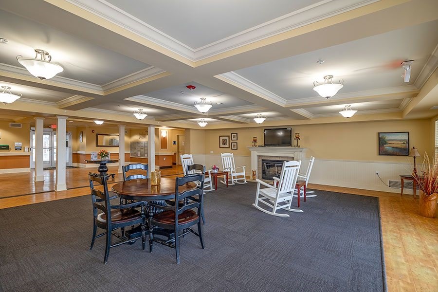 A large room with a fireplace and chairs.
