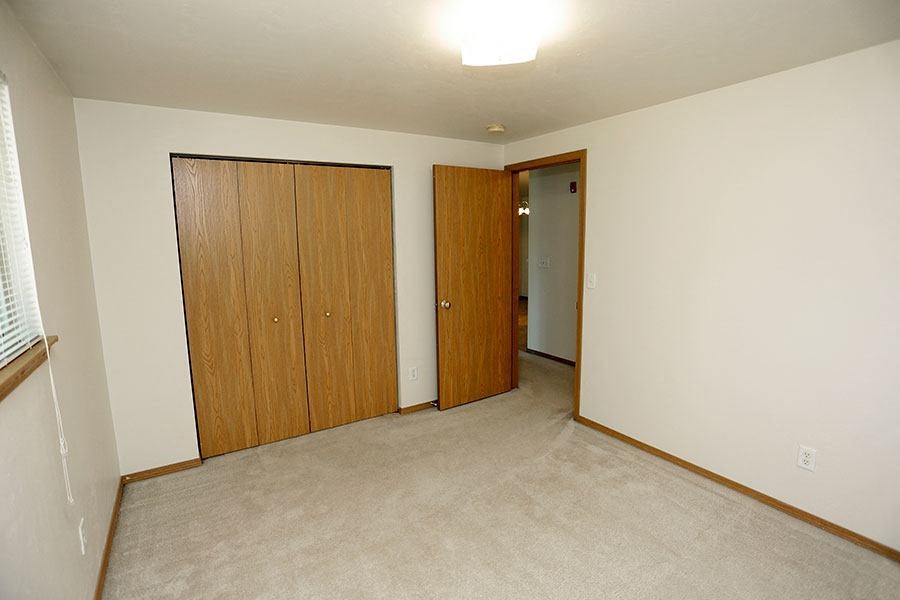 an empty living room with a door to a hallway