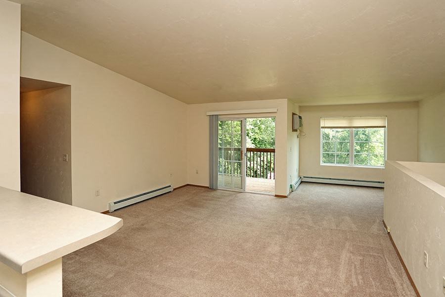 an empty living room with a door to a balcony