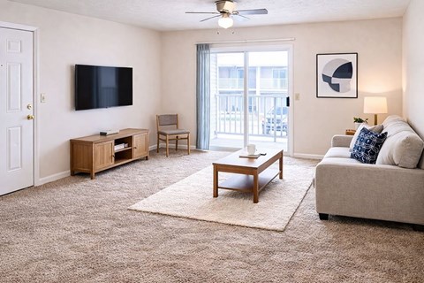A living room with a flat screen TV mounted on the wall.
