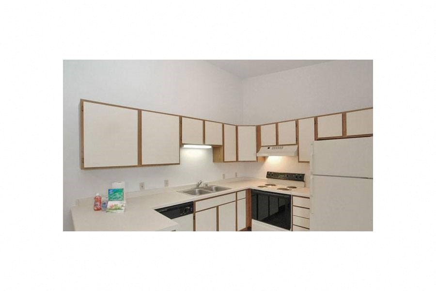 a kitchen with white cabinets and a stove and a sink
