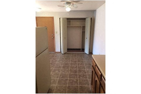 a kitchen with a refrigerator and a door to a closet