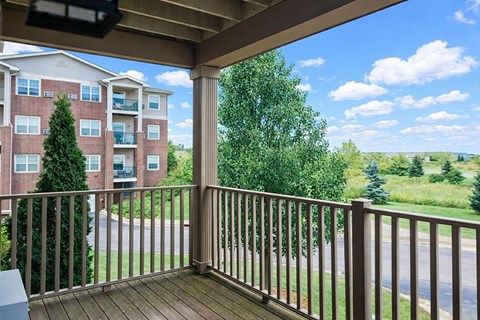 A balcony with a view of a road and trees.