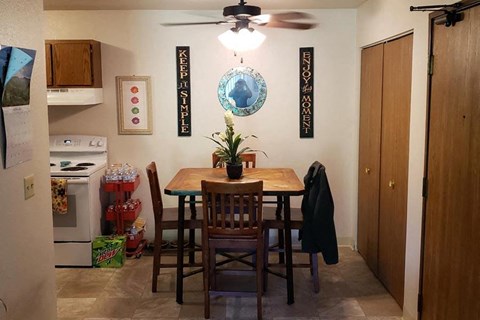 a dining room with a wooden table and chairs