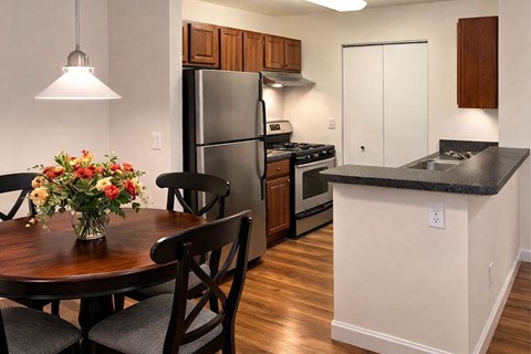 A kitchen with a table and chairs and a refrigerator.