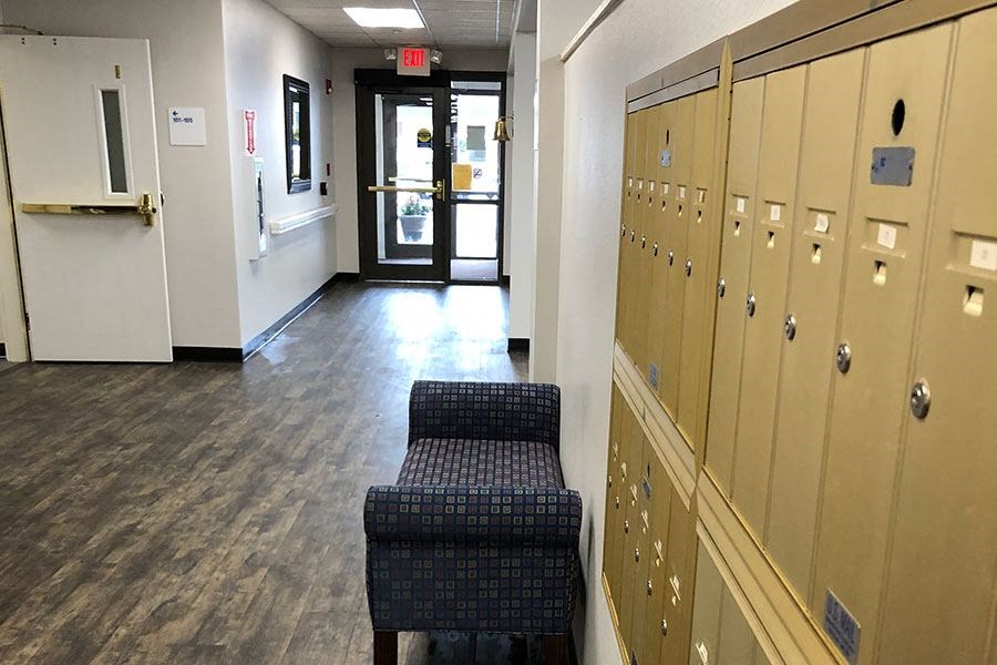 a hallway with a row of lockers and a bench