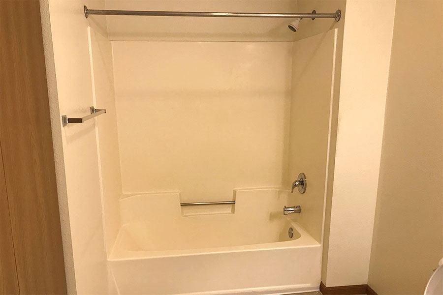 a white bathroom with a shower and a tub