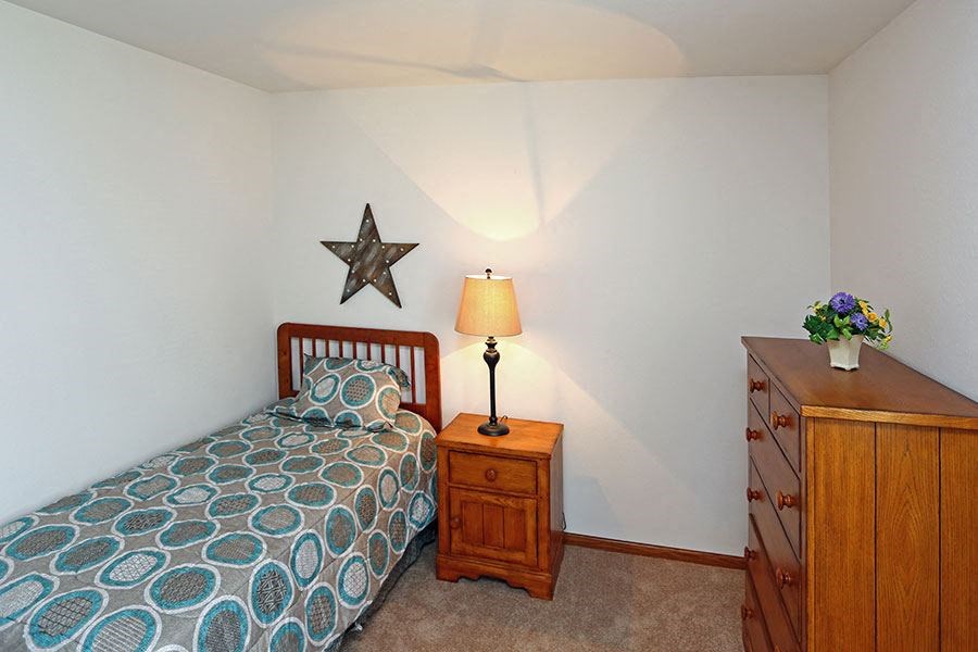 a small bedroom with a bed and a dresser