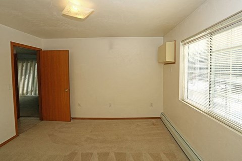 an empty room with a large window and a door