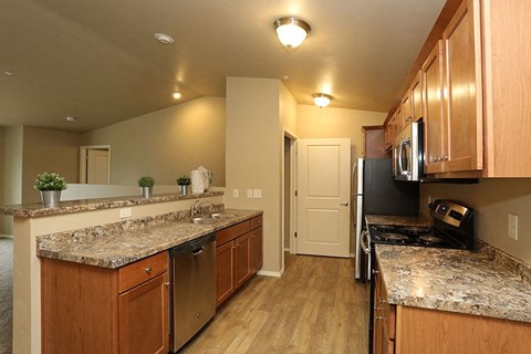 a kitchen with granite counter tops and wooden cabinets