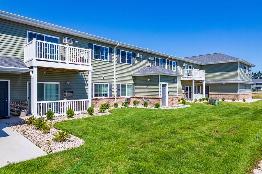 an apartment building with a yard and a balcony