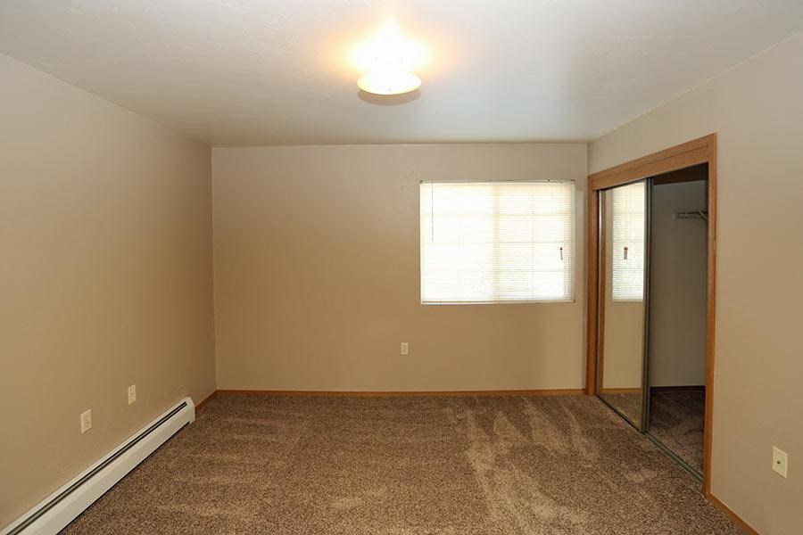 an empty room with a mirror and a window