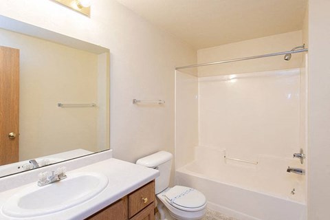 A white bathroom with a toilet, sink, and bathtub.