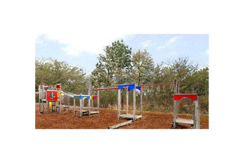 A playground with a red, blue, and yellow swing set.
