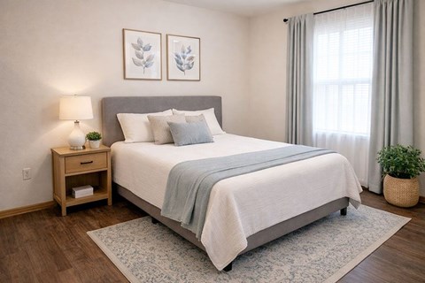 A bedroom with a large bed and a nightstand with a lamp.
