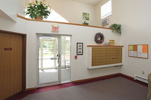 a lobby with an exit door and a plant