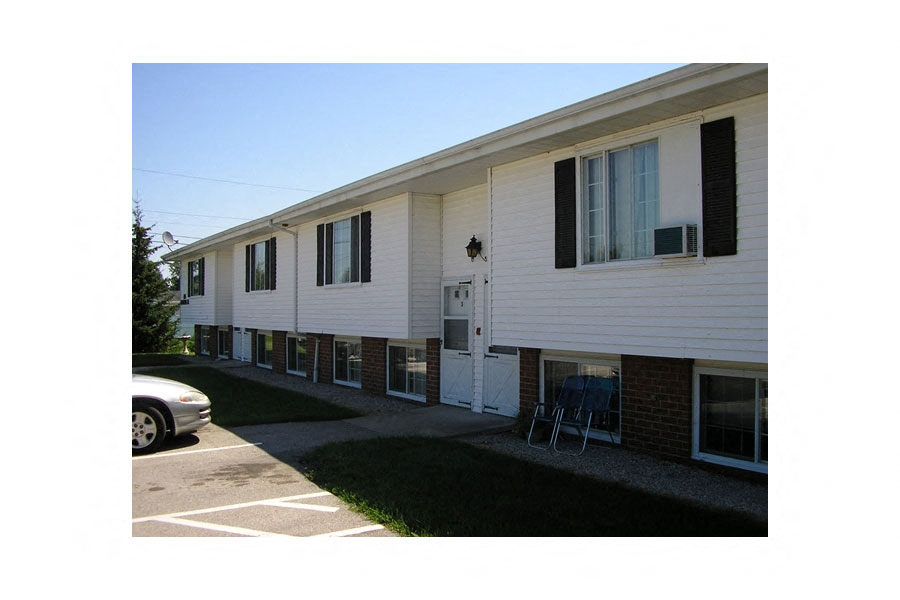 an apartment building with a car parked in front of it