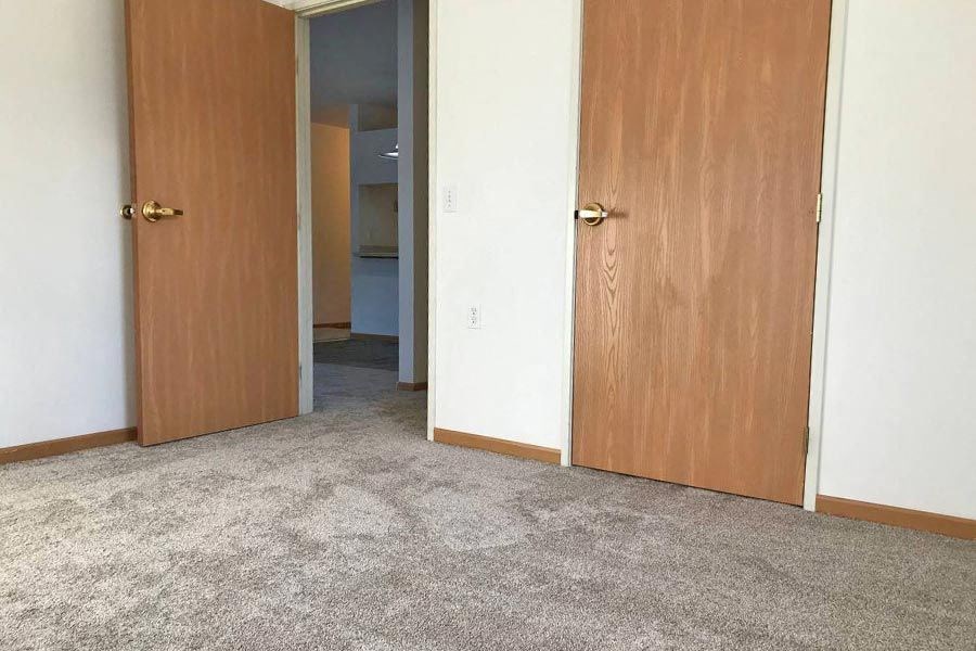 an empty room with three doors and a hallway