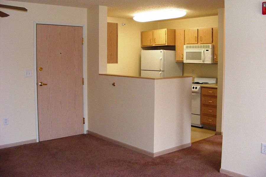 an empty kitchen with a refrigerator and a microwave