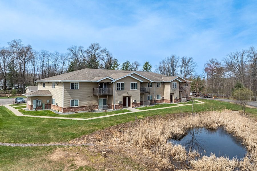 A large house with a pond in front of it.