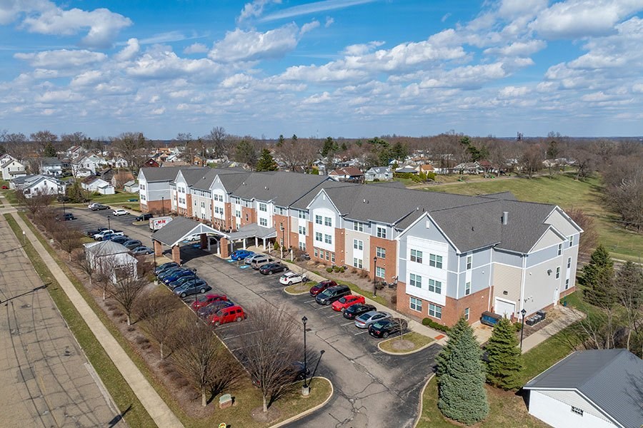 A large apartment complex with a parking lot in front.
