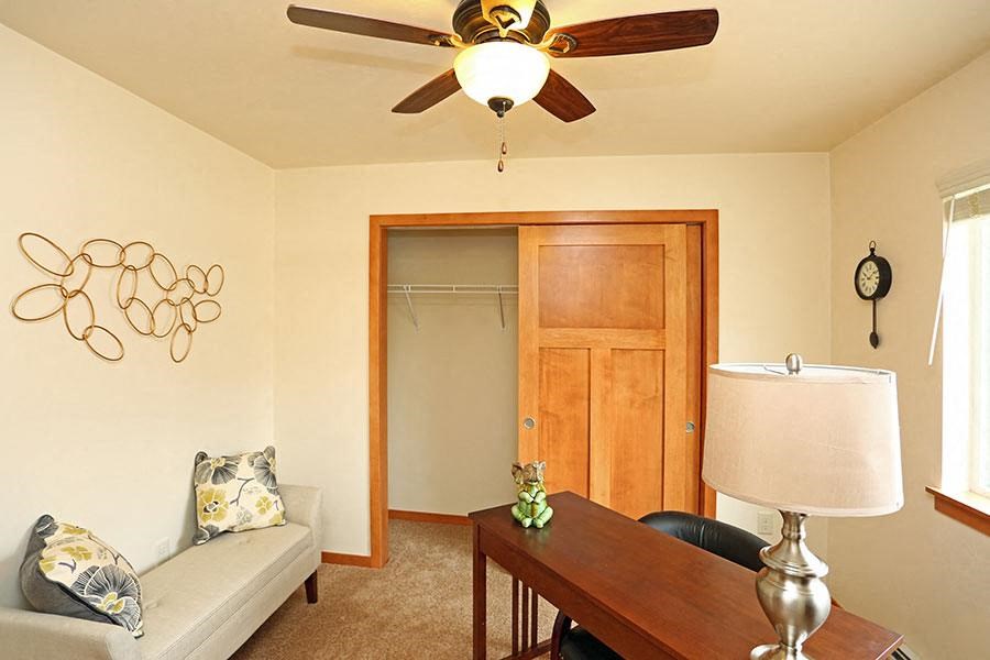 a living room with a ceiling fan and a table