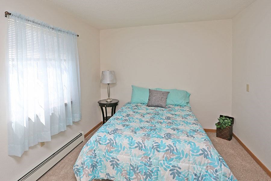 a bedroom with a large bed and a window