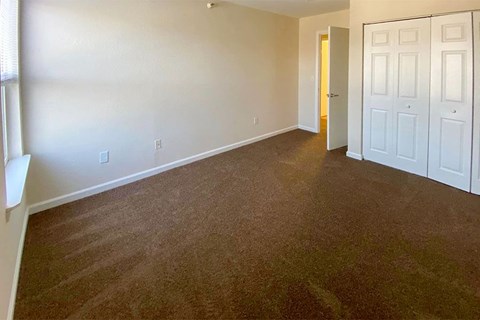an empty room with a carpeted floor and a white door