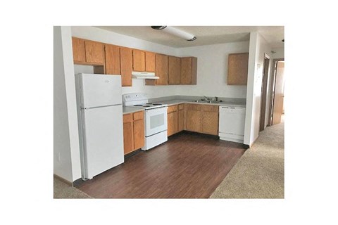 a kitchen with white appliances and wooden cabinets