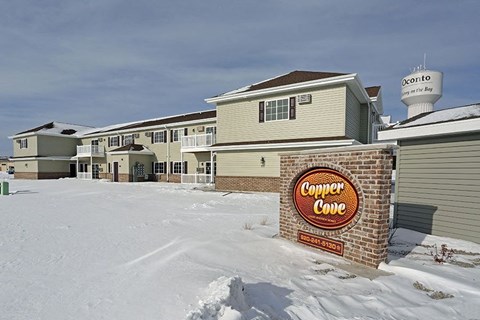 a condo condo building with a sign in the snow