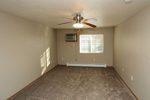 an empty room with a ceiling fan and a window