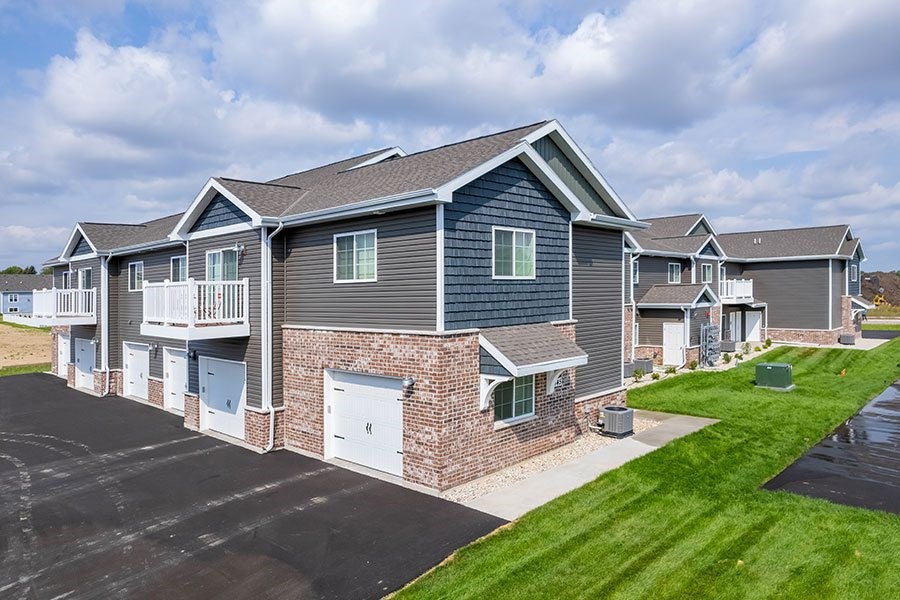 A row of houses with a driveway in front.