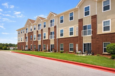 A row of apartment buildings with balconies and red trim.