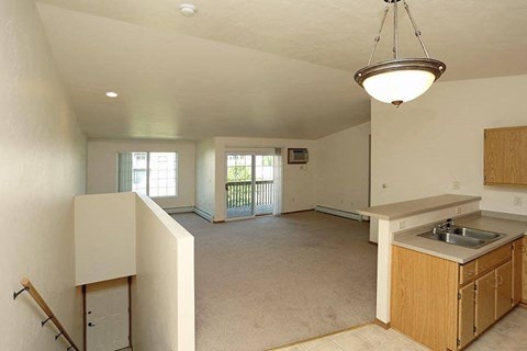an empty kitchen and living room with a sink
