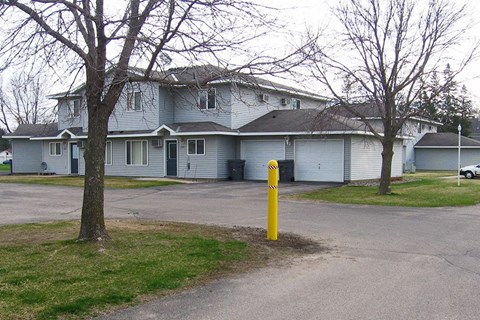 a blue house with a yellow pole in the street