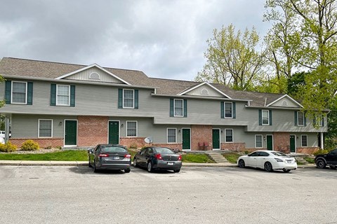 a large house with cars parked in a parking lot