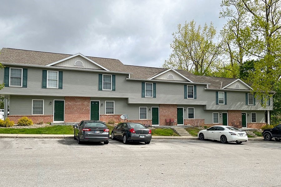 a large house with cars parked in a parking lot