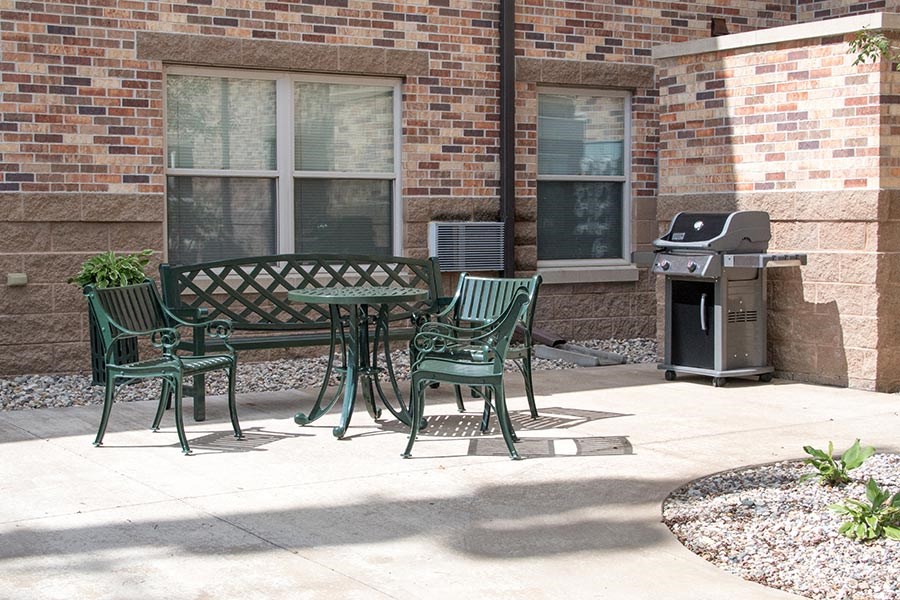 a patio with a table and chairs in front of a brick building