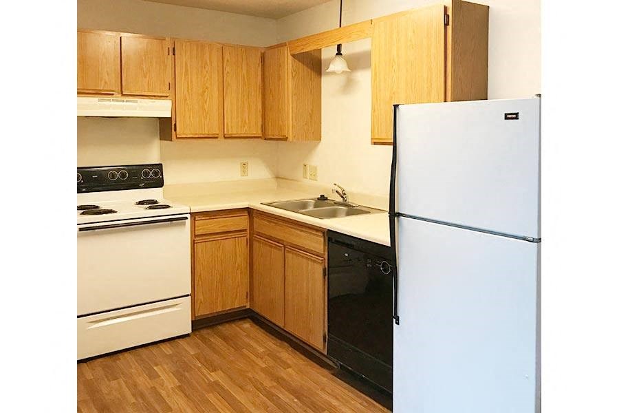 A kitchen with wooden cabinets and a white refrigerator.