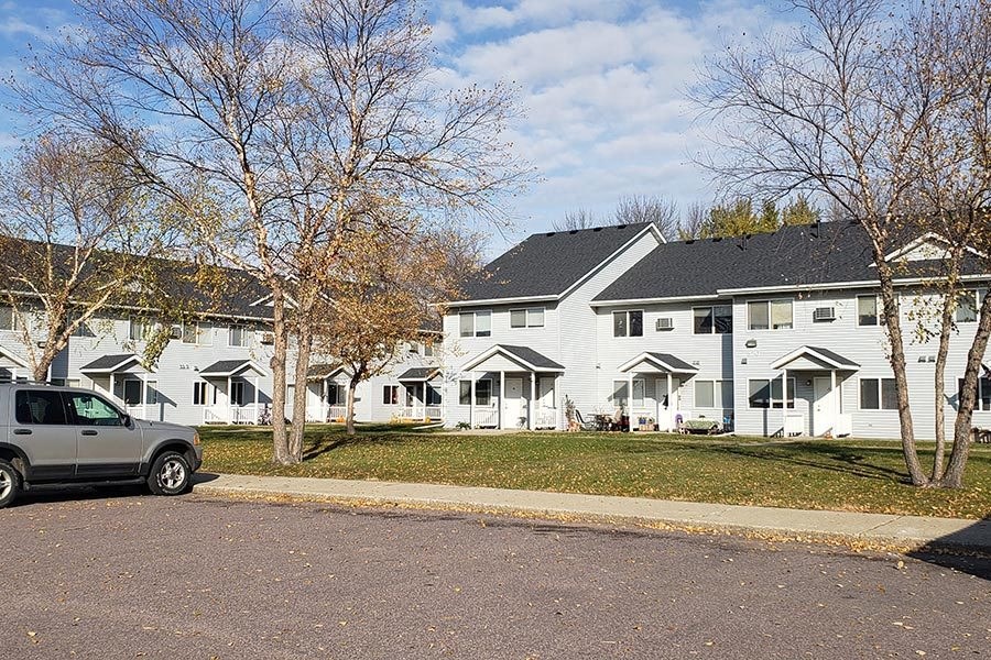 a truck parked in front of a row of white houses