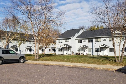 a truck parked in front of a row of white houses