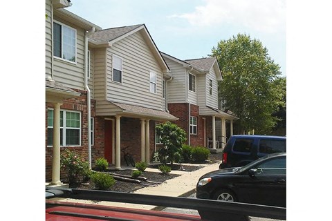 a row of houses with cars parked in front of them